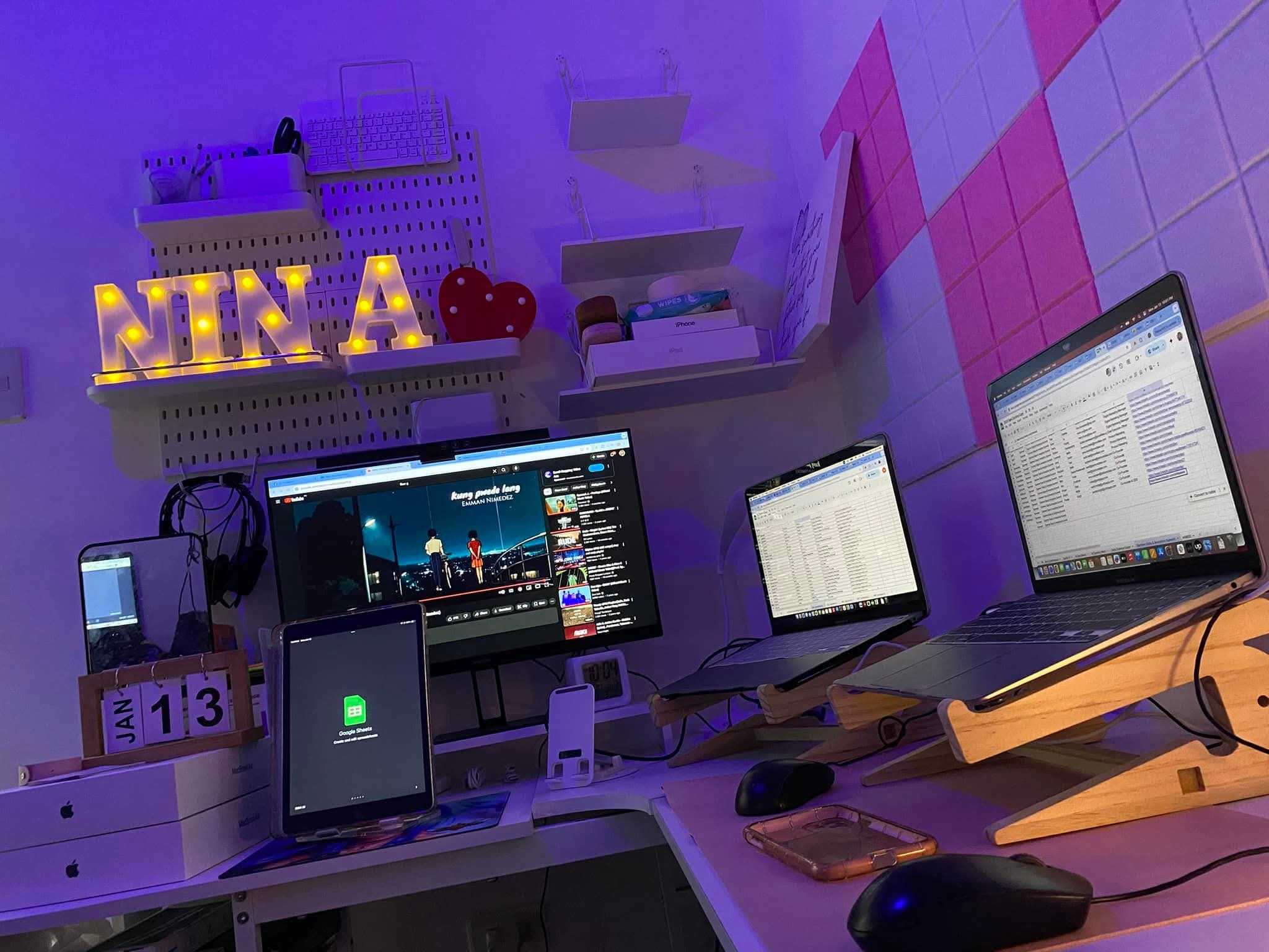 Nina's current workspace: external monitor, two laptops on stands, tablet, headset and her lit-up NINA sign